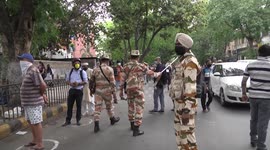 Indian police attempt to control large crowds queuing to enter liquor stores