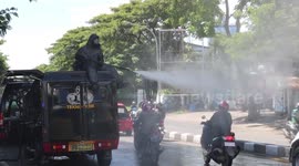 Police Personnel Spray Disinfectants into Vehicles Entering Makassar City