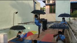 'Umbrella yoga' encourages social distancing while performing unusual poses in India