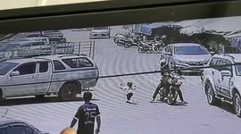 Heart-stopping moment Thai girl runs into road as motorbike rider narrowly avoids smashing into her