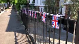 British flag bunting fluttering in the breeze on a railing outside a house