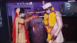 Bride, groom garland each other with long sticks to keep Covid 19 at bay