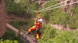 Chinese firemen rescue tourist trapped on 400-foot-high zipline after equipment failure