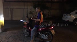 Cat hitches a ride on motorcycle taxi in Bangkok