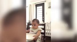 Sleepy Filipina baby tries to stay awake while eating her favourite food