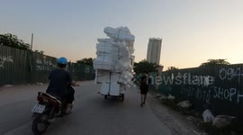 Ridiculously overloaded tricycle carries countless foam boxes on the streets of Vietnam
