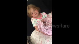 Newsflare Edit - Girl holds her new baby sister and the makes her smile