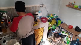A 2-year-old daughter helps her mother cook during the corona virus pandemic