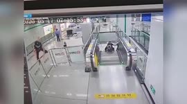 Chinese policeman hops over glass railing to stop escalator after elderly woman falls over on it
