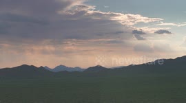 Mountainous Grassy Plains and Rain Clouds