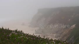 People on Top and Bottom of Cliff on Beach Cove