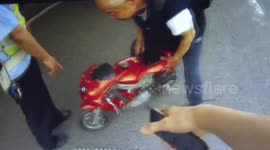 Police stop elderly Chinese man driving toy motorbike on busy road