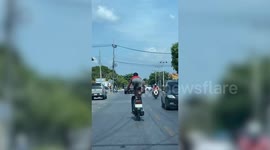 Motorcycle rider stuns passing drivers with bizarre stunts