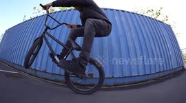 Cool BMX professional Athlete performs wheelie tricks on his BMX Bike / Blue Wall Visual