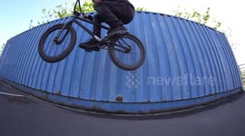 Cool BMX professional Athlete performs JUMP tricks on his BMX Bike / Blue Wall Visual