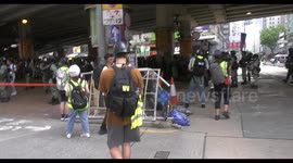 Bystanders are stopped and searched by riot police in Hong Kong