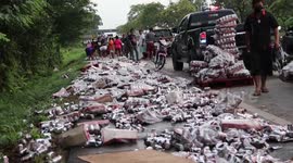 Truck spills hundreds of cans of beer sparking frenzy as Thai locals try to collect them