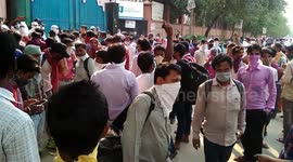 Indian migrant workers defy social distancing and queue up in hundreds to obtain tickets home