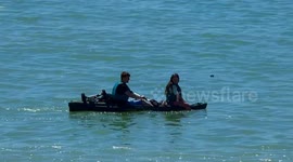 paddle boarding man and woman sunny day at sea