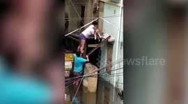 Two men rescue helpless dog trapped on building’s ledge after cyclone Amphan batters India