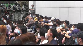 Hong Kong protesters corralled and made to sit down by riot police during rally against national anthem bill