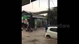 Motorists drive through flooded street in Bali, Indonesia