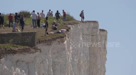 Keep back! Sun-seekers dice with death to take selfies on cliff edges on England's southeast coast