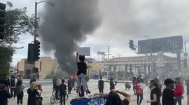 George Floyd Protestor standing in front of Los Angeles burning police car at George Floyd's Protest in LA 30th May 2020