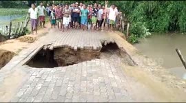Near miss for Indian villagers as road caves into flooded river