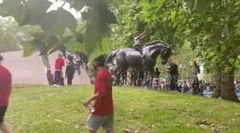 Black Lives Matter supporters sit on war memorial at London's Hyde park