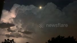 Intense lightning illuminates Toronto as the moon pokes through storm clouds