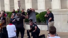 Three Chattanooga police officers take a knee during protest after repeated chants