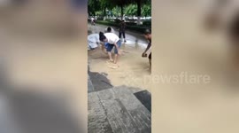 Chinese residents catch fish on flooded road after rainstorm