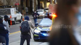 BLM protestor holds explicit sign in front of police car, Melbourne