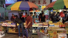 Shoppers buying fruits with police behind flashing strong lights towards them on 21 October 2019