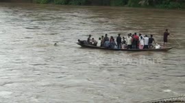 Terrifying moment Indian boatman plunges into flooded river but manages to swim to safety