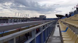 Racecars pass start line during warmup lap