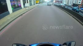 Woman dances in the road in front of biker