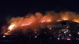 Brushfire erupts and illuminates Los Angeles night sky near 405 Freeway