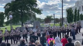 In front of line of police, Native American activists engage in dance in front of Minnesota state capitol