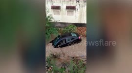 Parked car swept away in India during flash flood