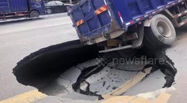 Transport truck gets trapped in sinkhole that opens up on road in China