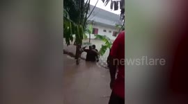 Family rescued from stranded car washed away by floods in Indonesia