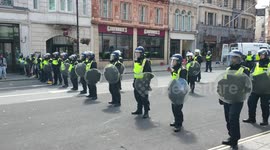 Police officers with dogs and shields line the roads in and out of Trafalgar Square after clashes between demonstrators and offices earlier