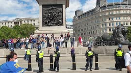 Far-right protesters stand on the base of Nelson's Column in Trafalgar Square following clashes between police and demonstrators.