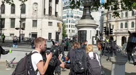 , police officers and police horses rushing to protect a man who has been seriously injured after protesters clashed in Trafalgar Square