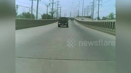 Motorcycle rider keeps his balance after clipping taxi on road