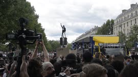 Masked activist climbs light to support Black Lives Matter march on streets of Paris