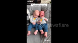 Chilled baby is totally fed up by his identical twin brother's crying