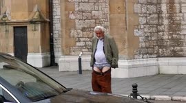 Old man walking half naked in the city core leaving shocked people